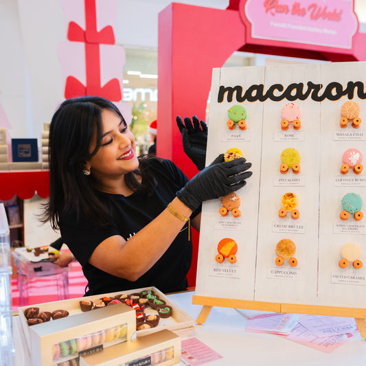 Founder adding macarons to a display board