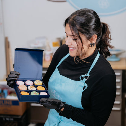 macaron baker holding luxury macaron packaging in toronto